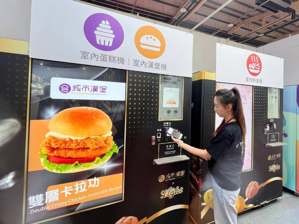 ▲國內知名連鎖早餐品牌「城市漢堡」成為焦點之一，首次公開亮相自家研發的「AI智慧販賣機」系統，主打24小時無人營運場景，實現從早餐到宵夜的全時段銷售布局。（記者蘇彩娥攝）