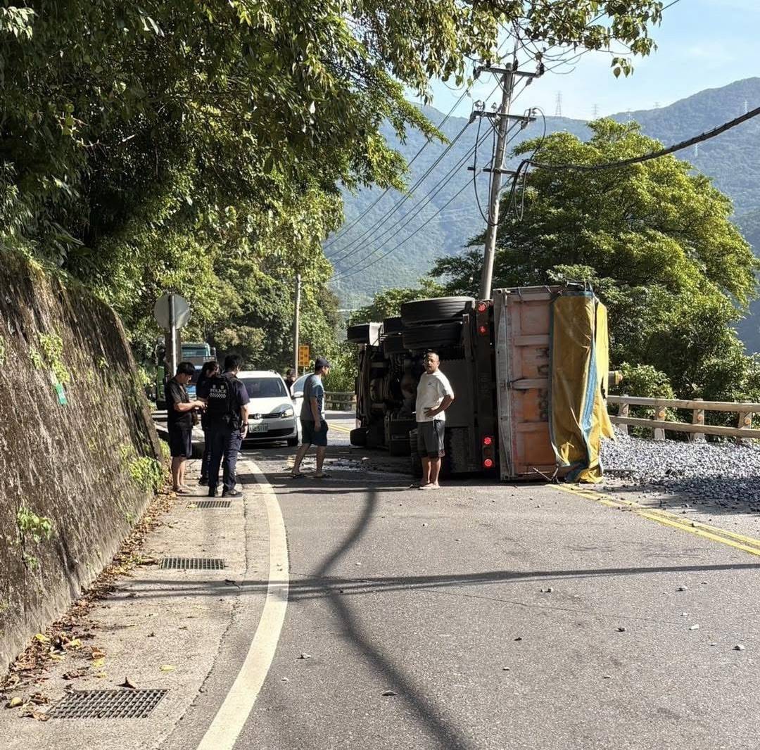 ▲曳引車疑因輪胎打滑,行經彎道時瞬間失控側翻,車斗內載運的砂石傾瀉一地,波及對向行駛而來的小客車,導致小客車擋風玻璃被碎石擊中。(翻攝自《記者爆料網》群組)