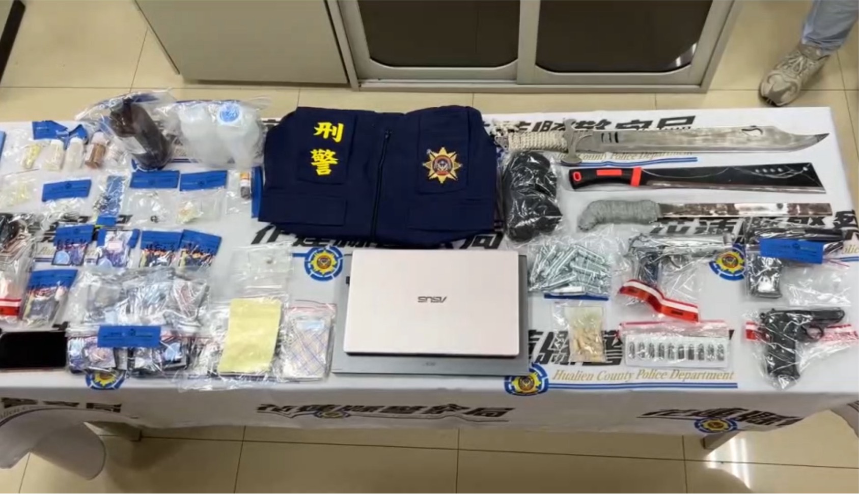 ▲警方日前展開掃黑行動,一舉攻堅11處據點,查獲14人到案,起出改造手槍、子彈、毒品、仿冒刑警背心等大量證物。(翻攝畫面)