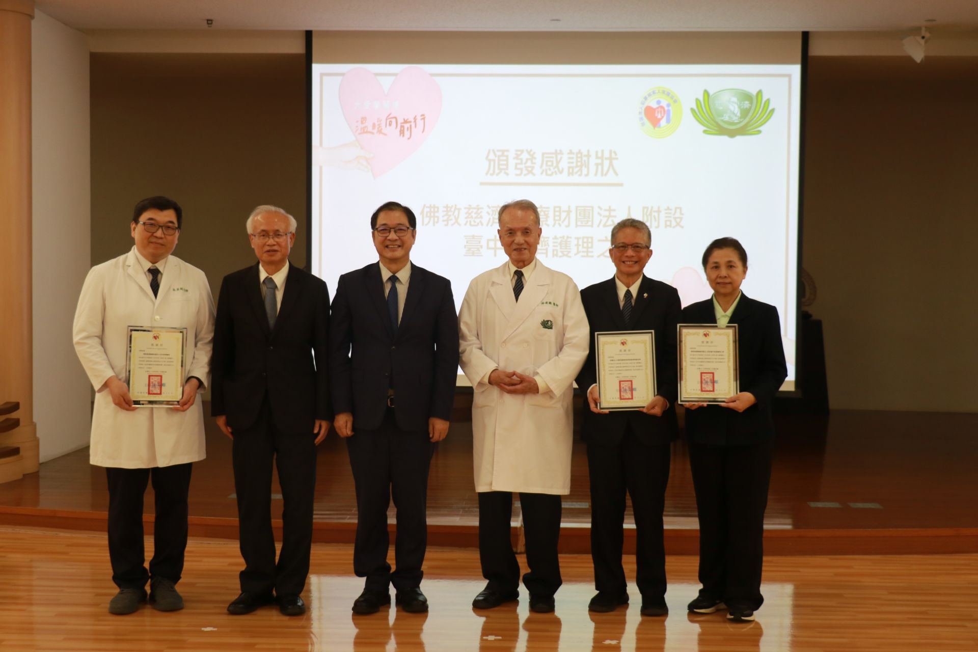 法務部部長鄭銘謙（左六）、法務部保護司司長洪信旭（右二）、犯保協會董事長張斗輝（左五）、慈濟基金會副執行長熊士民（右四）、慈濟醫療財團法人執行長林俊龍（右三）、犯保協會顧問林坤賢（右一）、台中慈院副院長莊淑婷（左四）等共同宣示「犯保有愛、慈濟大愛、嘉慧馨生」造福更多重傷馨生家庭。
