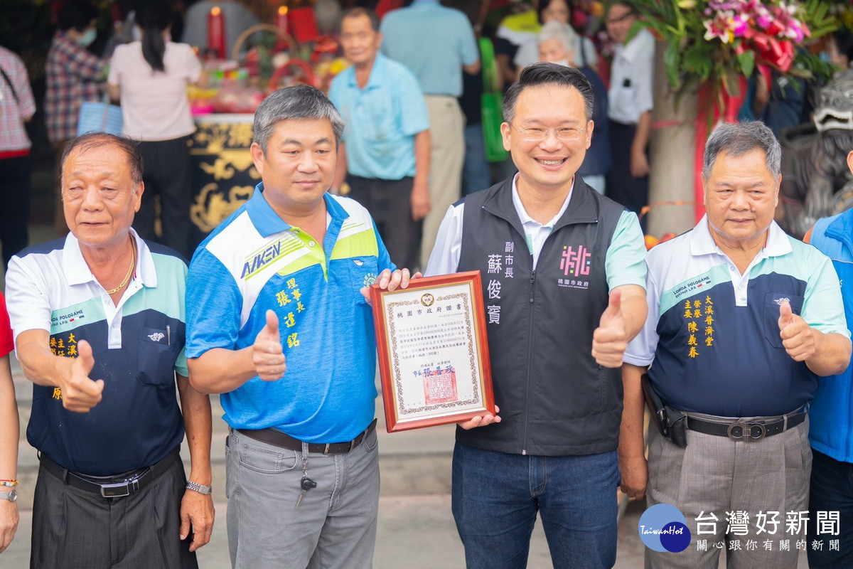 桃園市副市長蘇俊賓頒發無形文化資產民俗保存團體證書予大溪區社團民俗技藝協會理事長張逢銘。