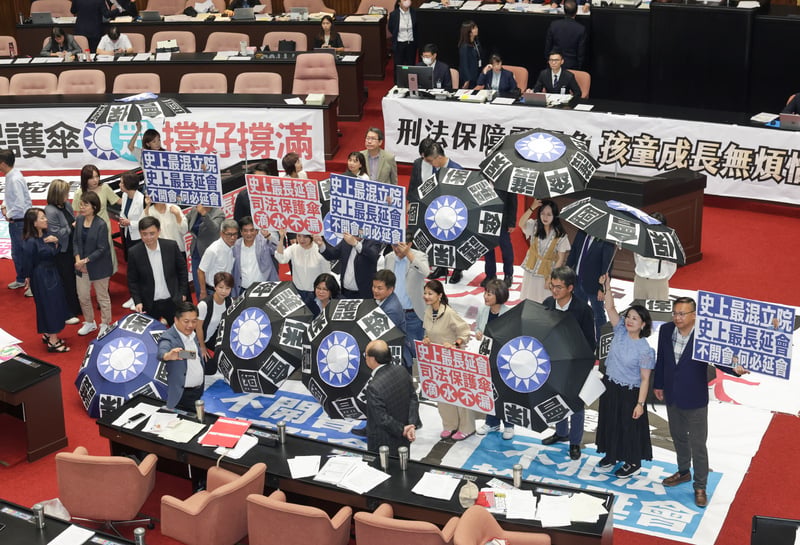立法院院會表決通過再延會至8月31日，民進黨立委手舉標語，質疑藍白延會是為將司法保護傘撐好撐滿。中央社