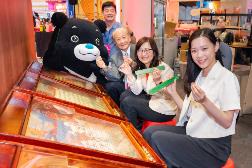 臺北市副市長林奕華（中）、觀光傳播局余祥局長（右）與台灣旅遊交流協會張家祝理事長（左），體驗「臺北館」夜市彈珠遊戲。(圖/臺北市政府觀光傳播局提供)