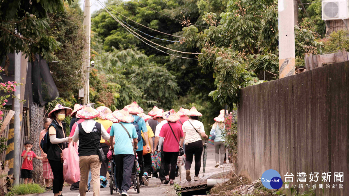 鎌村產業小旅行民眾戴著斗笠穿梭於田間小巷。