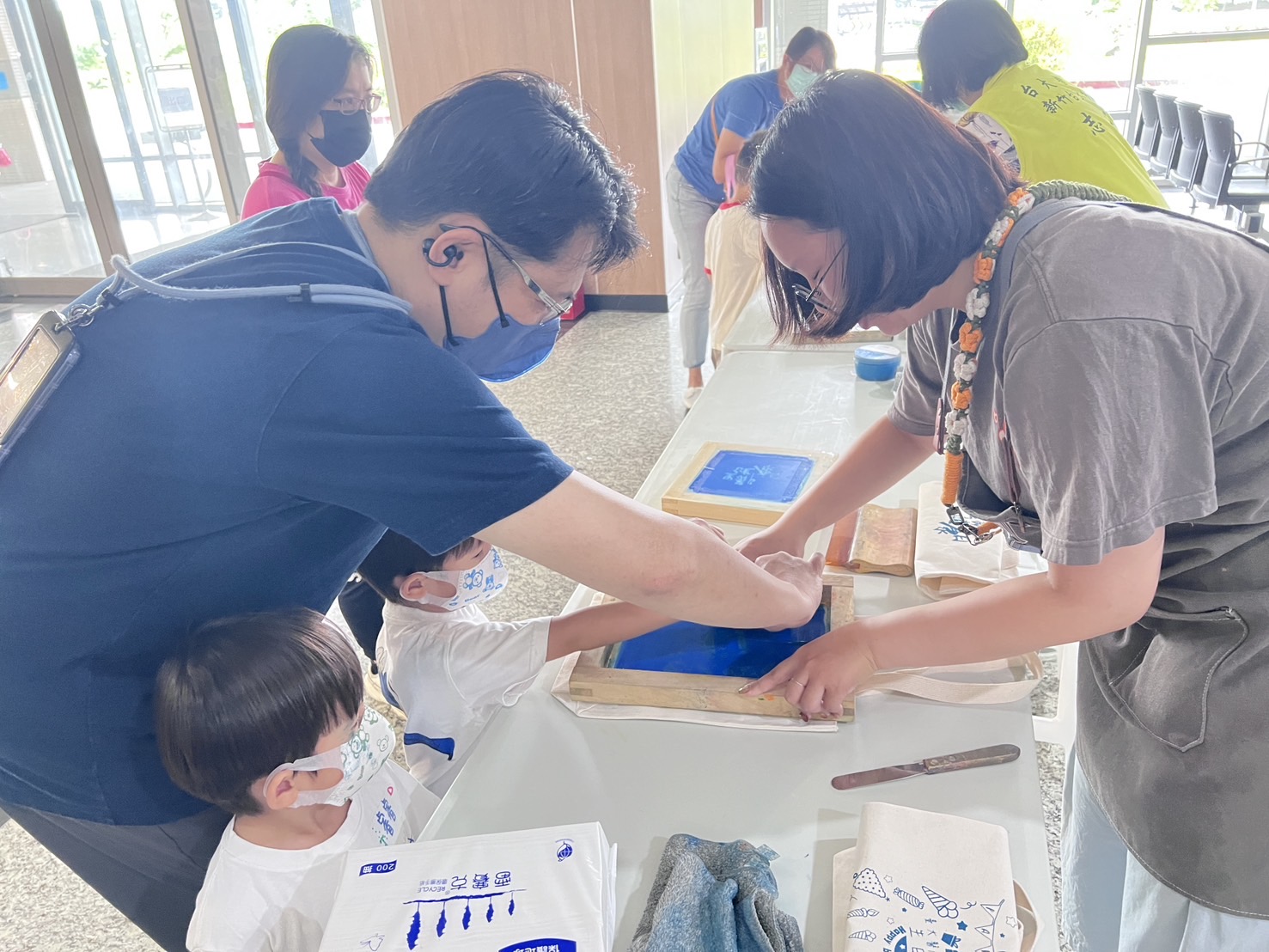 民眾與孩子們在志工協助下體驗絹印DIY,透過親手創作,將永續理念與健康生活落實於日常,活動氣氛熱絡,大小朋友都樂在其中。(圖/記者張家燁翻攝)