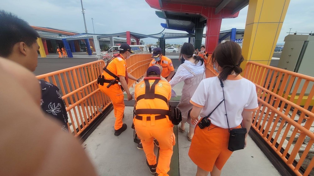 海巡署布袋商港安檢所協助昏迷的旅客下船送醫。(圖/海巡署提供)
