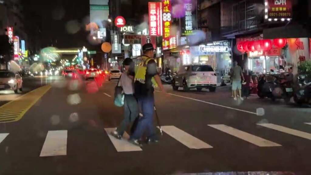 ▲老翁雨中穿越馬路陷車流,北屯所長立即現身化險。(台中警方提供)