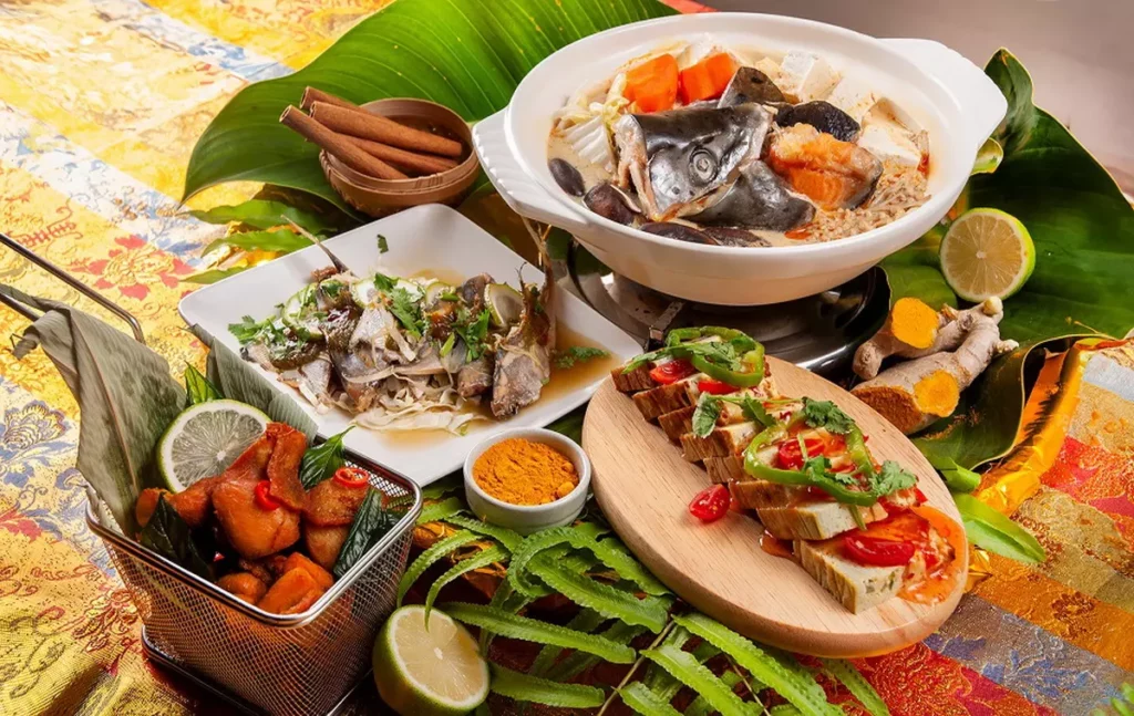 「南洋叻沙魚鍋」(上)椰香溫潤、尾韻甘甜;「薑黃炸雞」(下)外酥內嫩、香氣撲鼻;「現蒸檸檬魚」(左)酸香清爽、魚肉細緻;「泰式海鮮烘蛋」(右)蛋香融合海味,蓬鬆厚實。/台北凱撒大飯店提供