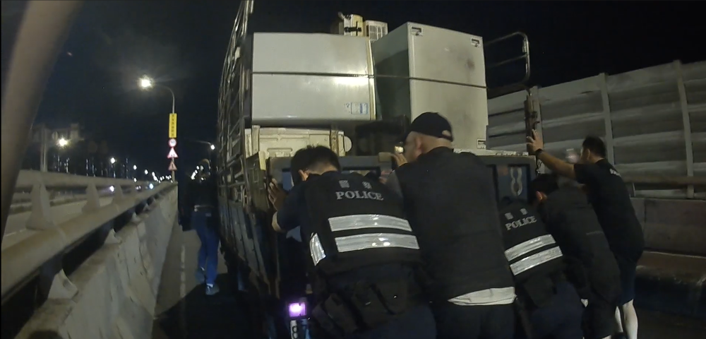 小貨車油盡熄火浮洲橋頂 板橋警民合力推車化解壅塞 1 《圖說》板橋警費力推動滿載著重物拋錨貨車。〈板橋分局提供〉