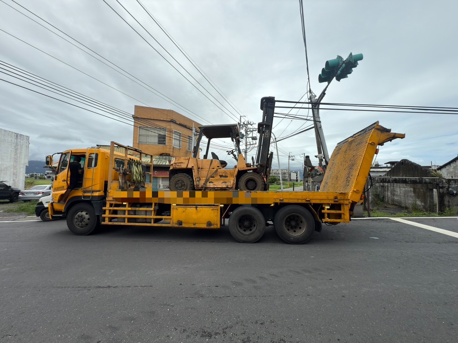 ▲42歲林姓男子駕駛大貨車行經礁溪鄉大塭路、大福路二段路口時,車上載運的推高機升降軌不慎勾住電線。(翻攝畫面)