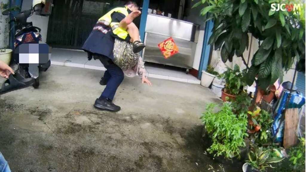 ▲失智老婦雨中跌倒車道,彰警暖心抱起護送返家。(彰化警方提供)
