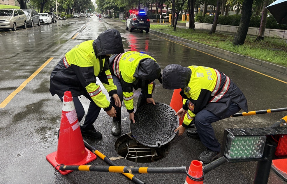 ▲圖說：中市文心南七路上人孔蓋扛不住水流而浮起，南屯所員警緊急以三角錐警示，並重新將人孔蓋固定 （圖／台中市政府 提供）