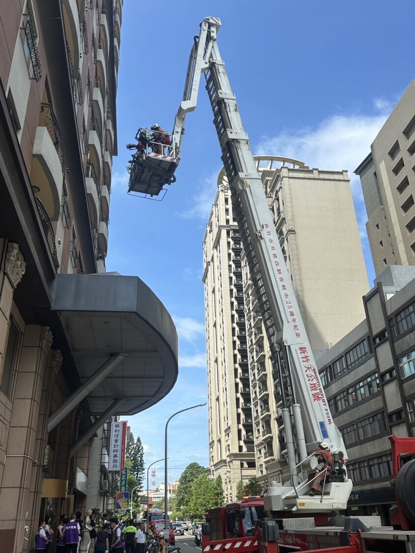 新竹市消防局於敦煌大樓消防演練中出動雲梯車,模擬高樓層火警人員救援,展現高空應變與垂直疏散實戰能量。(圖/記者張家燁拍攝)