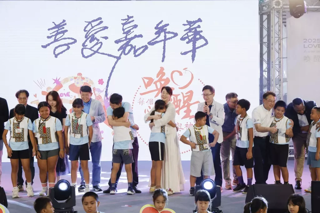 左起台北金融研究發展基金會 周吳添董事長、小樹傳愛協會 陳俊秀 副理事長、發起人Dammy老師和外貿協會 黃志芳董事長上台與學童一起進行擁抱心運動