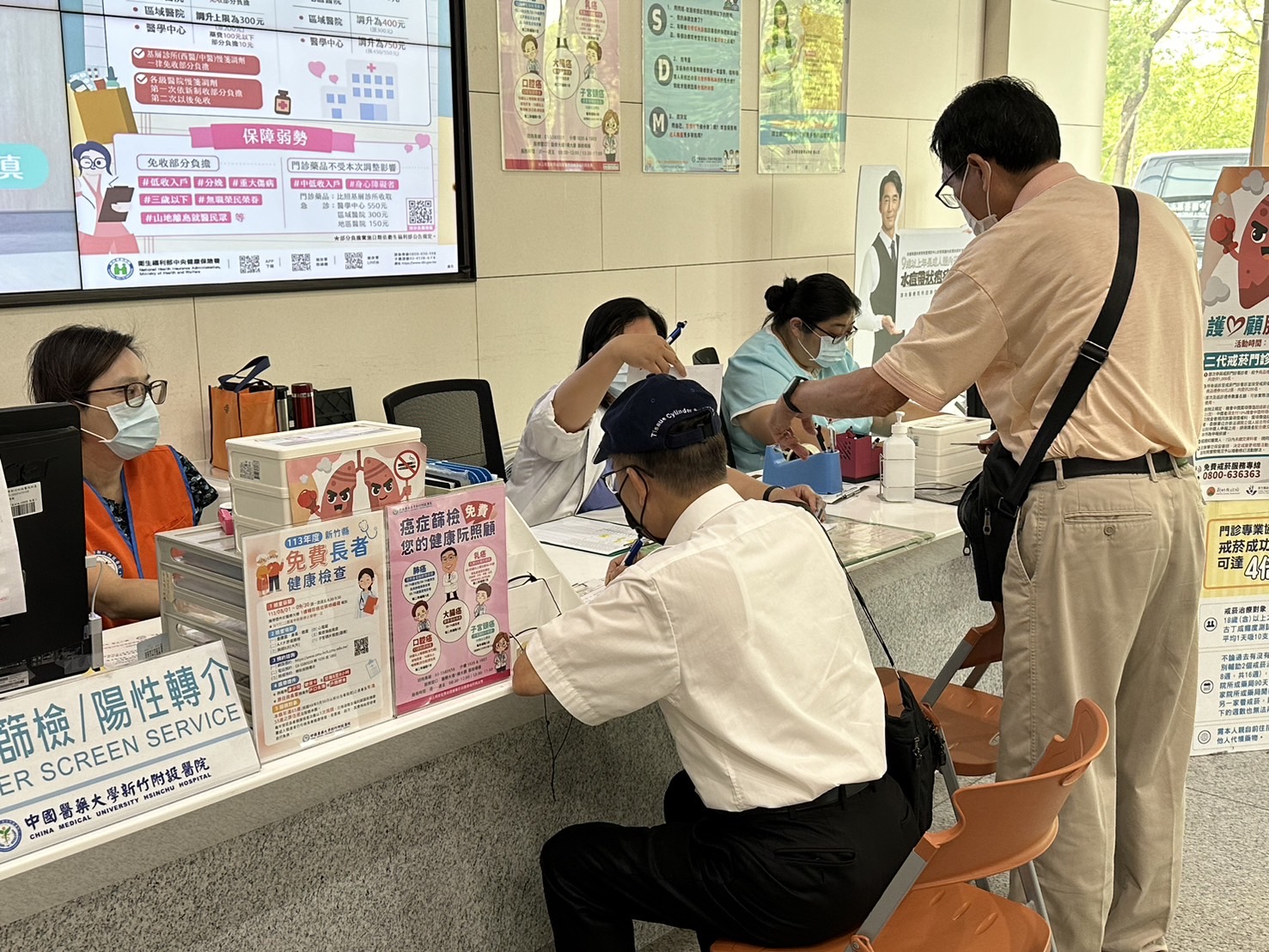 民眾於中醫大新竹附醫健檢櫃檯報到登記,醫護人員與志工團隊細心引導流程,協助長者順利完成各項免費健康檢查。(圖/記者張家燁翻攝)