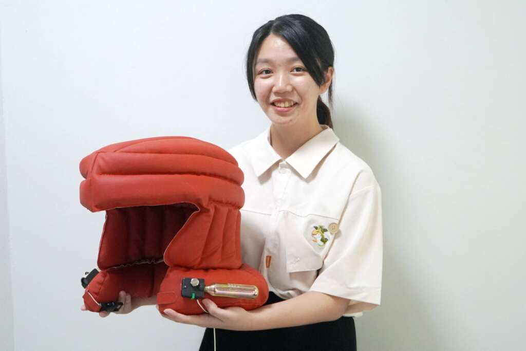 ▲大葉大學工設系畢業生黃郁容展示「兼具照明功能之充氣式頭盔」。(記者林明佑翻攝)