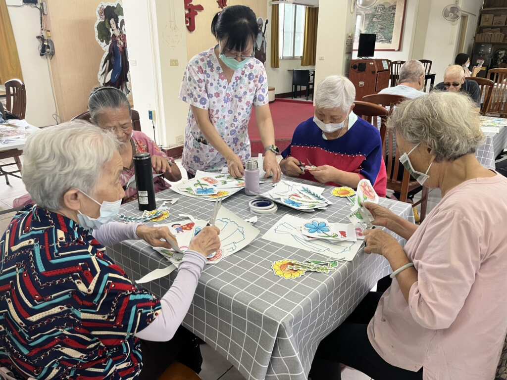 ▲為了讓住民們感受到父親節的歡樂氣氛,彰化榮家攜手臺中榮總埔里分院舉辦「花花世界-紙藝活動」,由埔榮社工師劉玉惠帶領長輩們利用雙手與剪刀一同創造出美麗的花束作品。(彰化榮家提供)