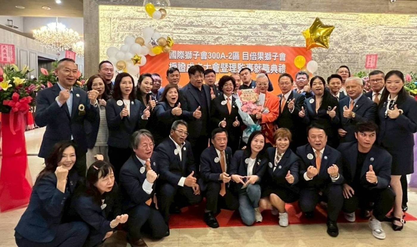 台北市目倍果獅子會創會長林宏展（持花束者）與到場祝賀的各區獅友及嘉賓熱情合影。（圖／目倍果獅子會）