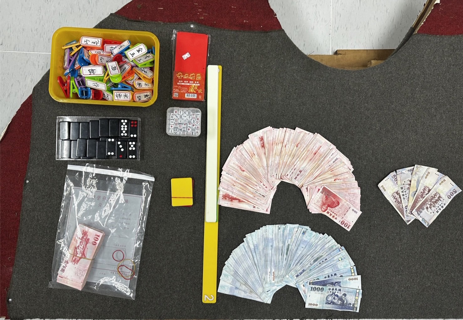 ▲警方現場共查扣賭資新台幣11萬500元、抽頭金1萬8400元，以及賭具天九牌1副、賭桌、清注尺等證物。（翻攝畫面）