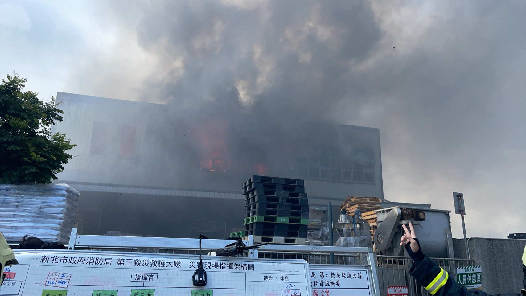 ▲新北市八里區1處位於商港五路上的2層樓高鐵皮工廠,於今(13)日清晨6時許突然冒出大量黑煙。(翻攝畫面)