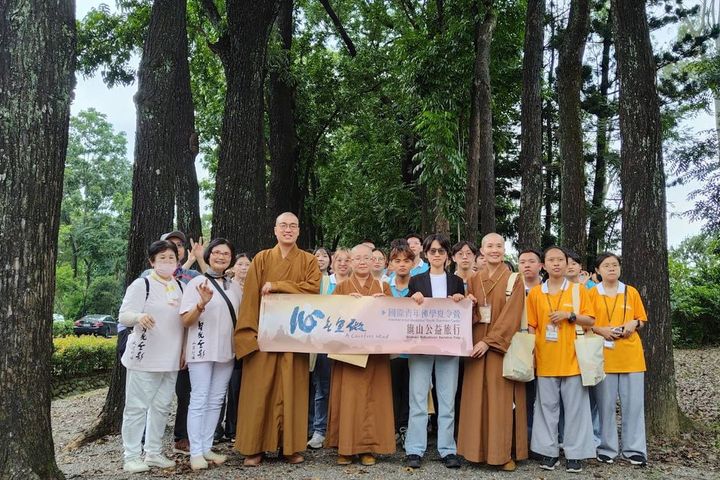 佛光山佛學夏令營一行人與茂管處黃怡寧科長於桃花心木下合影。 圖:茂林國家風景區管理處/提供