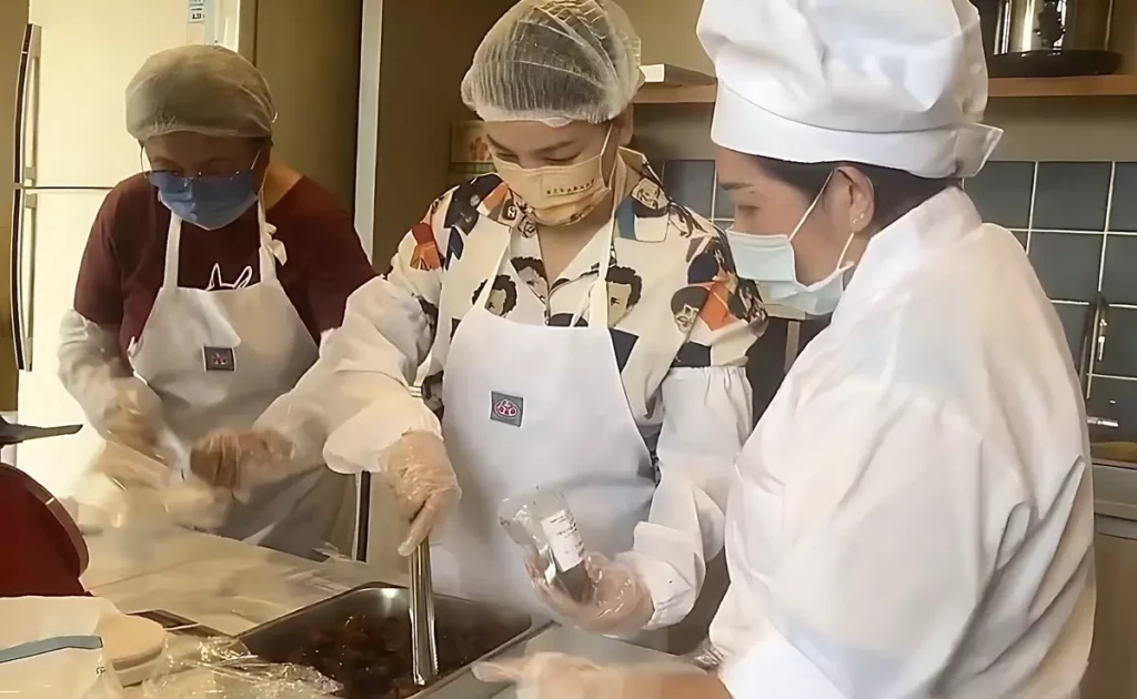 身兼多重照顧責任的芷婷(中)在芥菜種會萬里營地學習包裝冷料理包,以工「帶振」的彈性工時,協助她在家庭與收入間取得平衡。(芥菜種會提供)