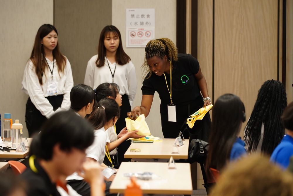 淨零未來 新北2025國際青年氣候論壇即起報名 3 《圖說》綠色女孩平台志工Christiana Rosha分享馬拉威以木屑和花生殼等材料製作生物炭的過程,此替代品可以提高安全性和促進環境保護。〈環保局提供〉