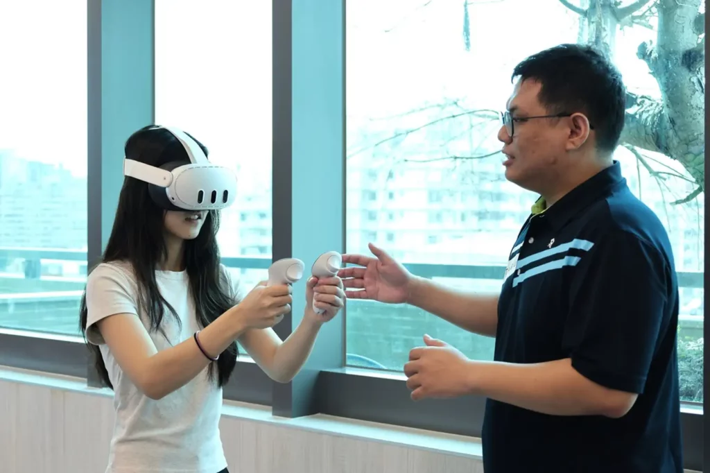 職安系鄭喻齊助理教授（右）引導學生體驗VR防墜設備。（圖/中山醫大提供）