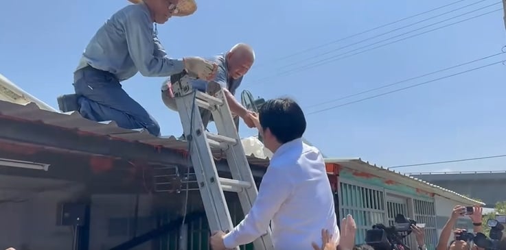 總統賴清德7度視察台南災後復原,爬鋁梯上屋頂送水給工班致意。總統府提供