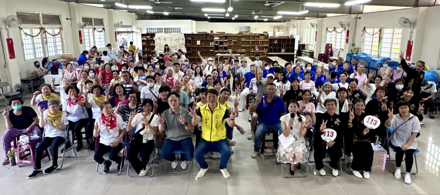 香山樂齡中心葉國文主任帶領志工一同於祖孫傳情許願牆前合影。(圖/記者林照東攝)
