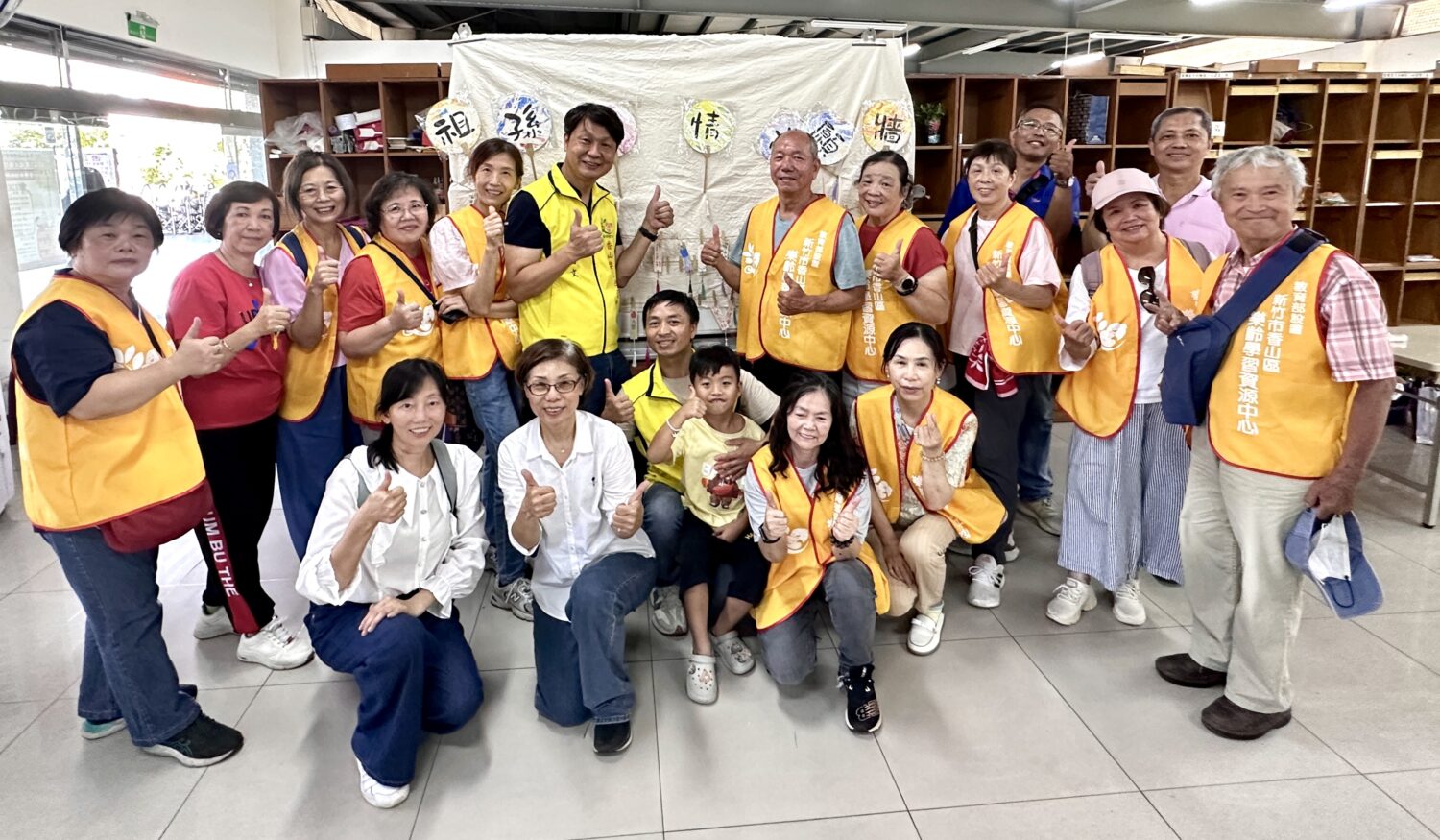 香山樂齡中心葉國文主任帶領志工一同於祖孫傳情許願牆前合影。(圖/記者林照東攝)