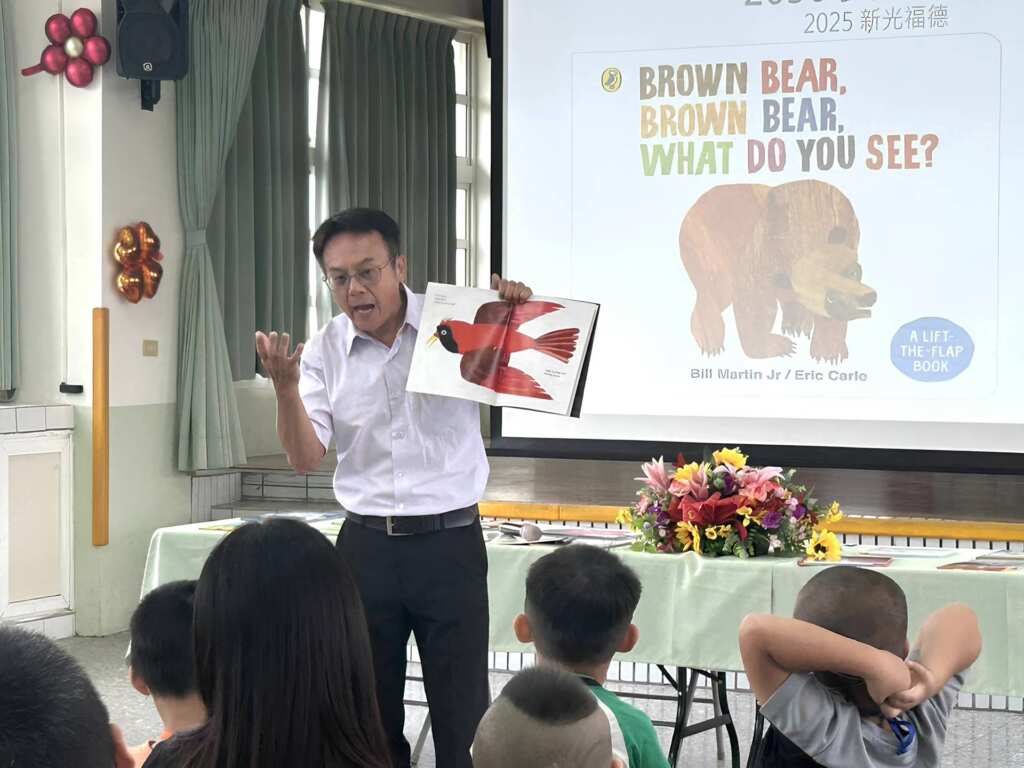 ▲活動由福德國小校長卓鴻賓化身的「卓爺爺」溫馨開場，他拿著一本色彩豐富的英語繪本(Brown Bear, Brown Bear, What Do You See?)，為新生及家長們講述關於環境與食農教育的有趣故事，為迎新日注入濃濃的書香氣息。（記者林明佑翻攝）