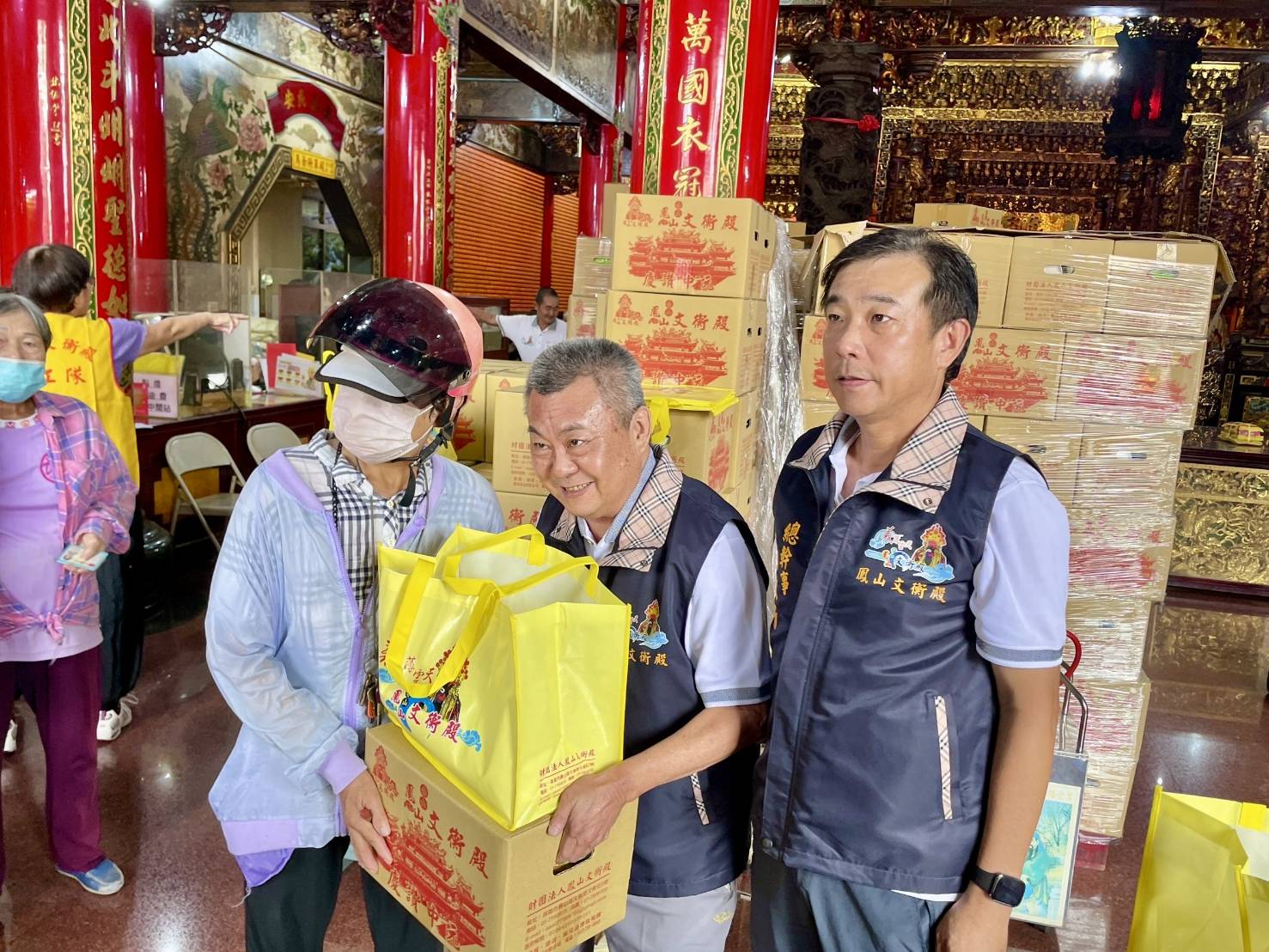 ▲鳳山赤山文衡殿舉辦「慶贊中元」普渡法會，並化供品為「愛心禮盒」分送清寒家庭，新任董事長楊世忠（中）及幹部親自將物資交到民眾手中，傳遞關聖帝君忠義與濟世精神。