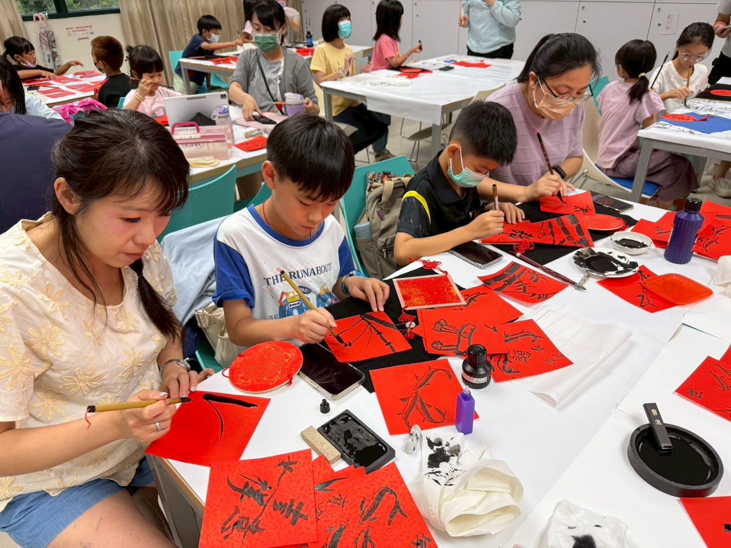 桃市圖中壢分館舉辦書法大師講堂 9位重量級名家輪番開講 家長帶著孩子一起學習書畫的畫面十分溫馨