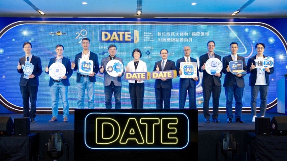 第11屆DATE SUMMIT聚焦全球佈局與數位賦能 7國18位講師 共探未來商業新契機 2 ▲貴賓手持DATE與數位經濟象徵之手舉牌大合影,左至右依序為:外貿協會數位商務處處長黃漢唐、CreatorDB產品管理與AI應用資深總監Dominic Cope、Taiwan Global Angels創辦人詹益鑑、總體經濟學家吳嘉隆、經濟部國際貿易署黃瀞萱主任秘書、外貿協會王熙蒙秘書長、聚界潔能股份有限公司臺灣董事長谷月涵、玉山國際加速器(Mosaic Venture Lab)總經理Volker Heistermann、意藍資訊股份有限公司創辦人暨總經理楊立偉、SUPER 8 Studio雲發互動科技創辦人暨執行長陳子龍。