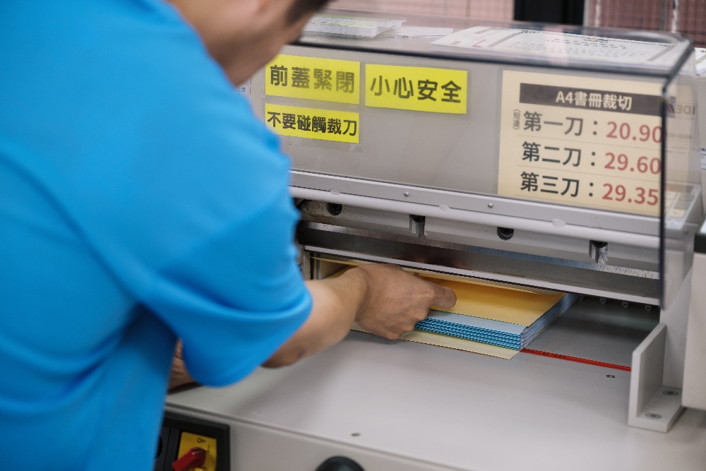 ▲昱全用手指確認每張紙都有對齊。(圖/庇護工場提供)