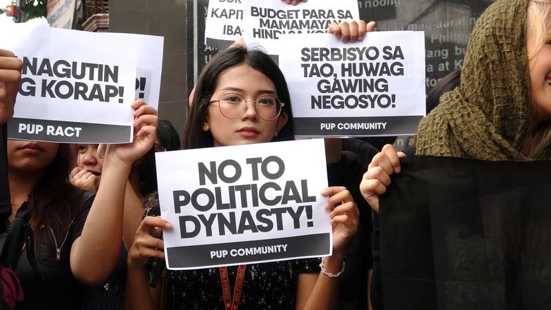 菲律賓理工大學(PUP)學生15日在校門口示威,抗議政府防洪工程大規模貪污。圖為1名學生舉牌反對容易引發貪污的家族政治。 中央社