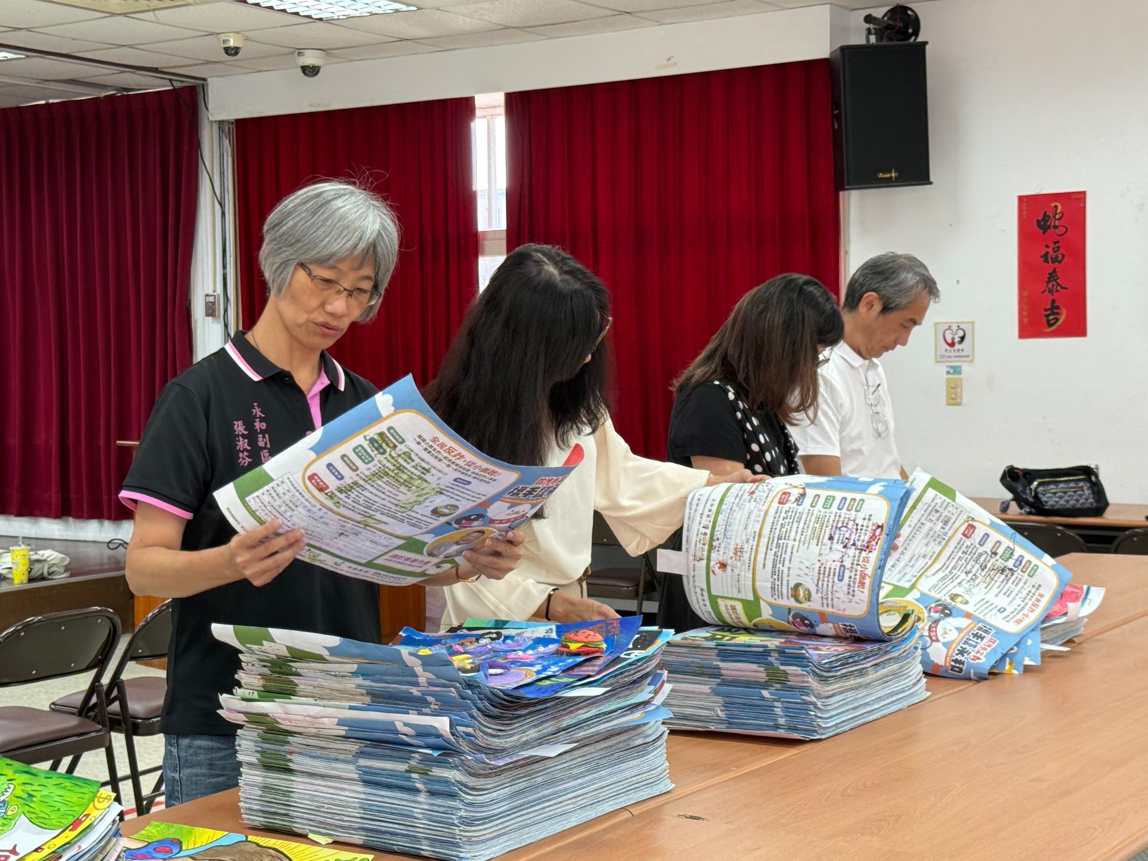 防詐小尖兵繪畫賽 逾千作品攜手護永和 3 《圖說》永和區副區長及中嘉寬頻|新視波總經理仔細審閱作品。〈主辦單位提供〉