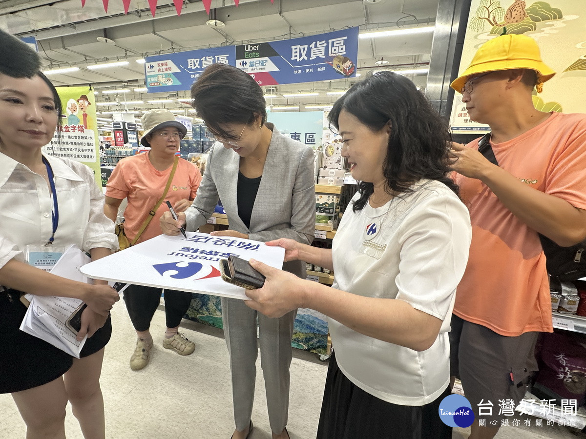 許淑華為家樂福與各業者簽名。(記者扶小萍攝)