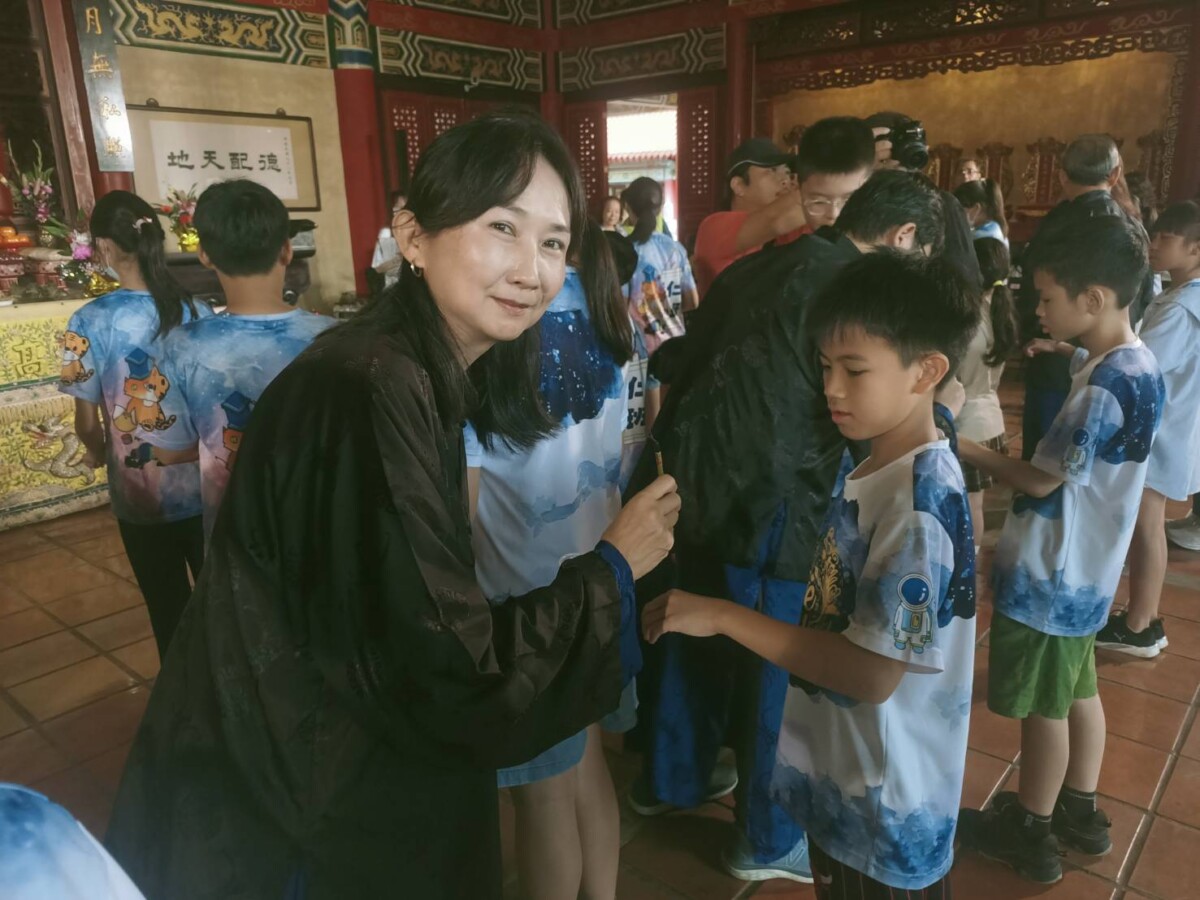 ▲旗山區長莊家柔，以紅墨在學子手背上圈選祝福，象徵智慧開啟（記者 李堂安 翻攝）