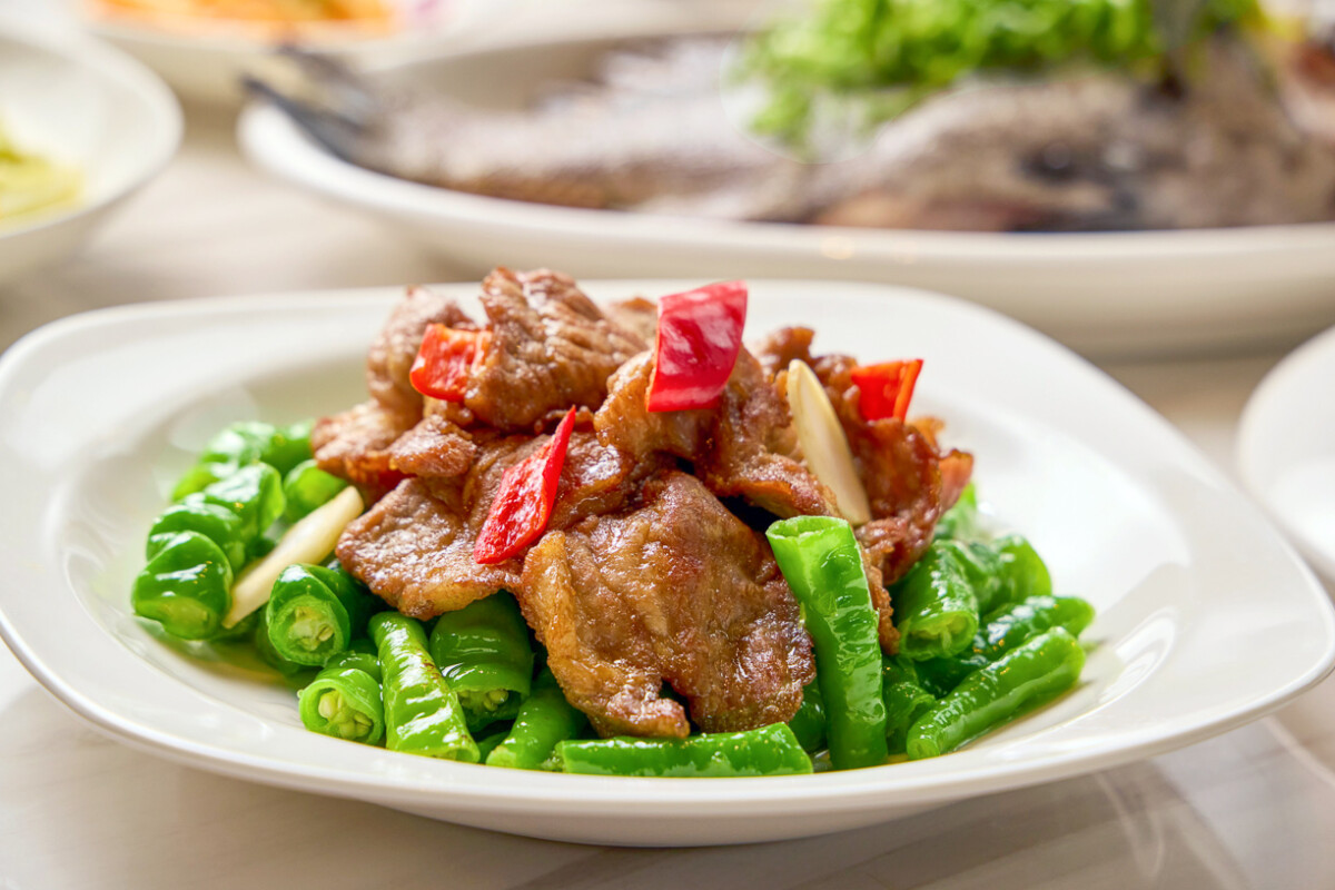 ▲「青龍豉椒黑豚肉」以美濃特有的青龍辣椒搭配伊比利黑豚。豬肉經快炒後保持軟嫩，與青龍辣椒的辛香結合，辣度溫和不嗆，鹹香下飯。（圖/高雄萬豪酒店提供）