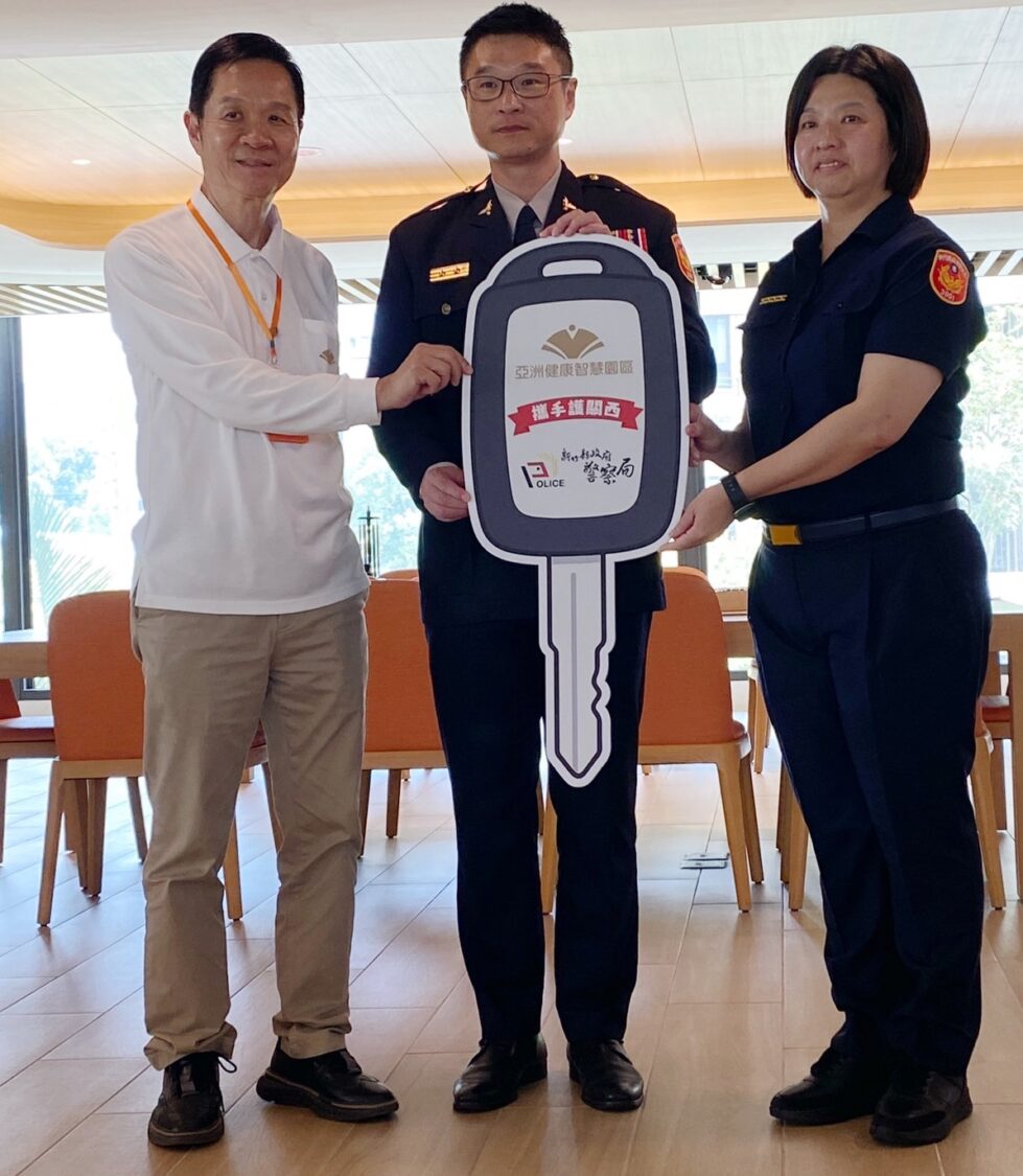亞洲健康智慧園區董事長彭培業(左)將象徵鑰匙模型交付新竹縣警察局長林建隆(中)、新埔分局長張舒喻(右),象徵巡邏車正式啟用。(圖/記者張家燁翻攝)