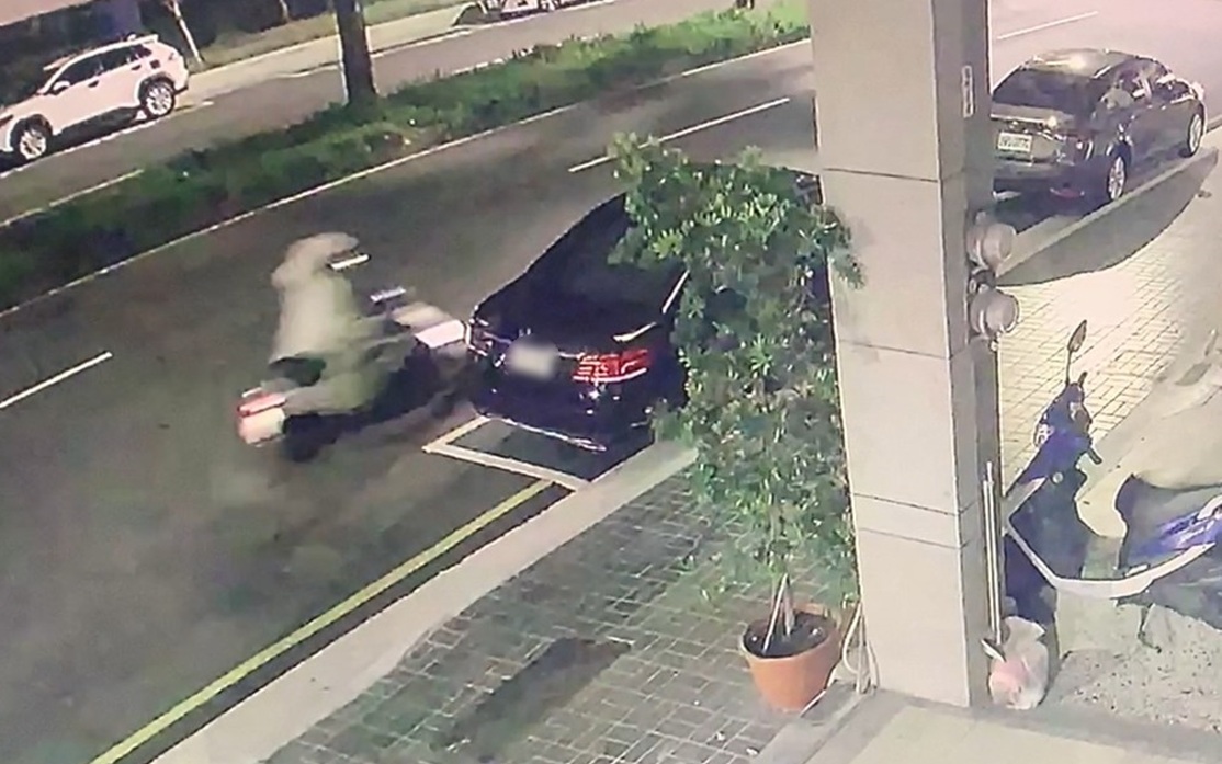 ▲圖說:一名身穿雨衣騎士騎車擦撞路邊車輛後,機車重心不穩摔倒 (圖/台中市政府 提供)