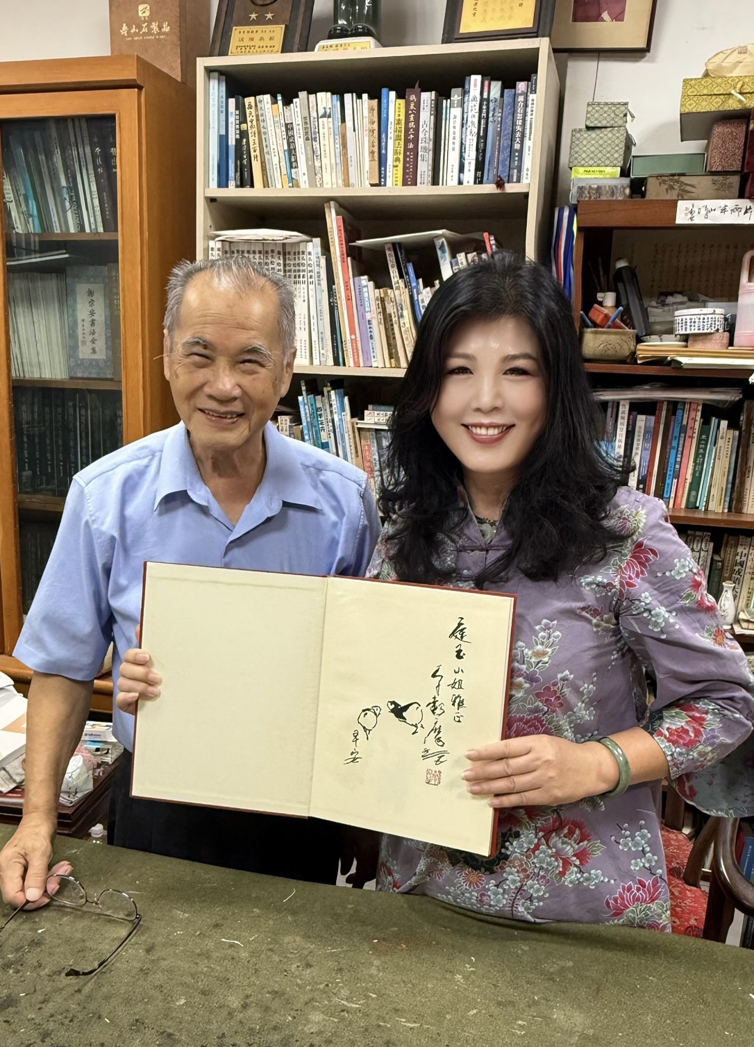 李穀摩老師在畫冊扉頁親繪雙鳥並題字,寓意吉祥與傳承,並贈予廖庭玉理事長留念。