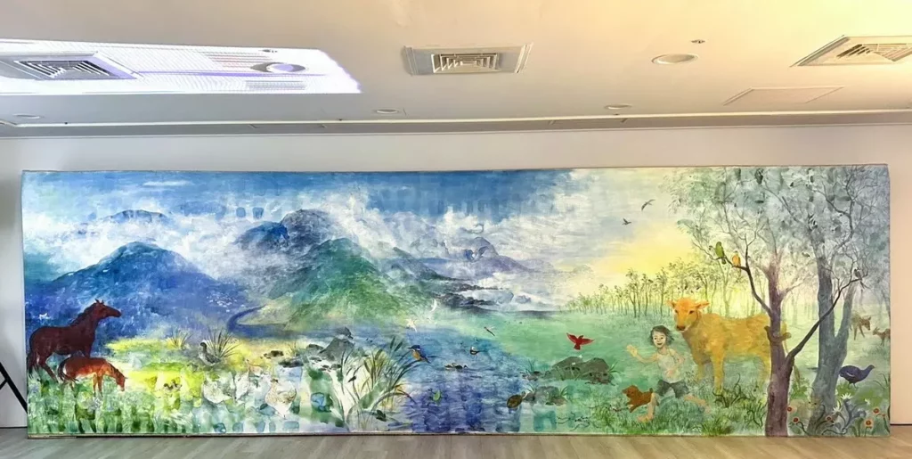 現場展出藝術家吳優的巨幅畫作「一個嚮往的世界」,期望人與萬物、環境和諧共存。