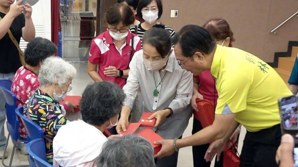 ▲大通電子董事王寶雍逐一發放慰問金林世賢市長則贈中秋月餅禮餅。(記者林明佑攝)