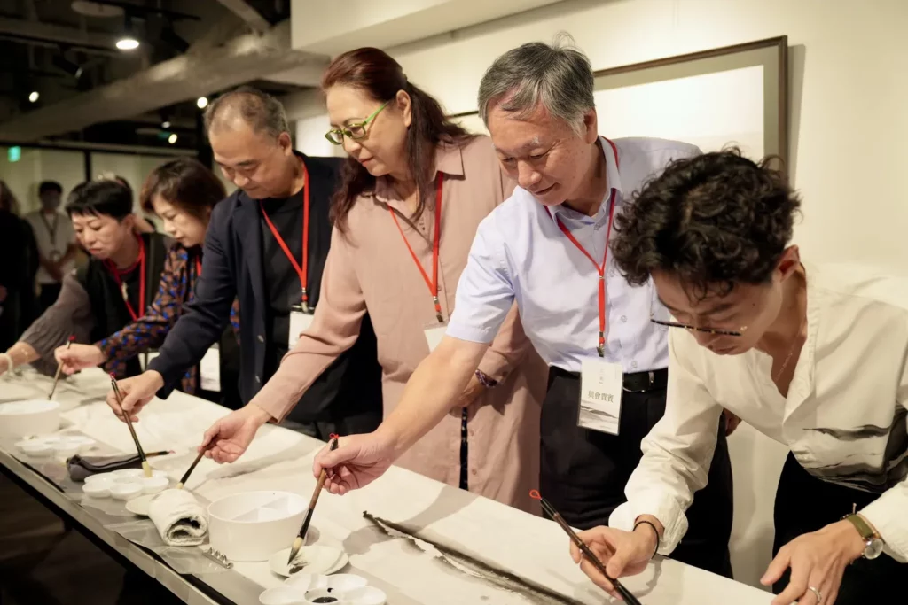 「共創時刻」由沈榮親自領筆,與其他貴賓共同創作「靈性山水」長軸。(圖由世界宗教博物館提供)