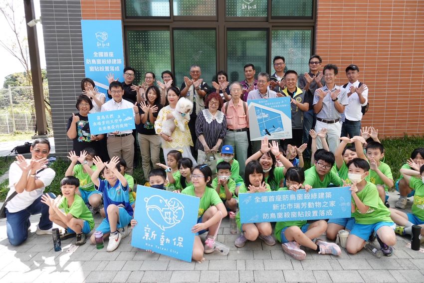 喜迎世界動物日百周年 新北打造全國首座防鳥窗殺綠建築 2 《圖說》新北市農業局、動保處、野保團體、瑞芳區長楊勝閔及瑞芳國小師生於防窗殺玻璃前合照。〈動保處提供〉