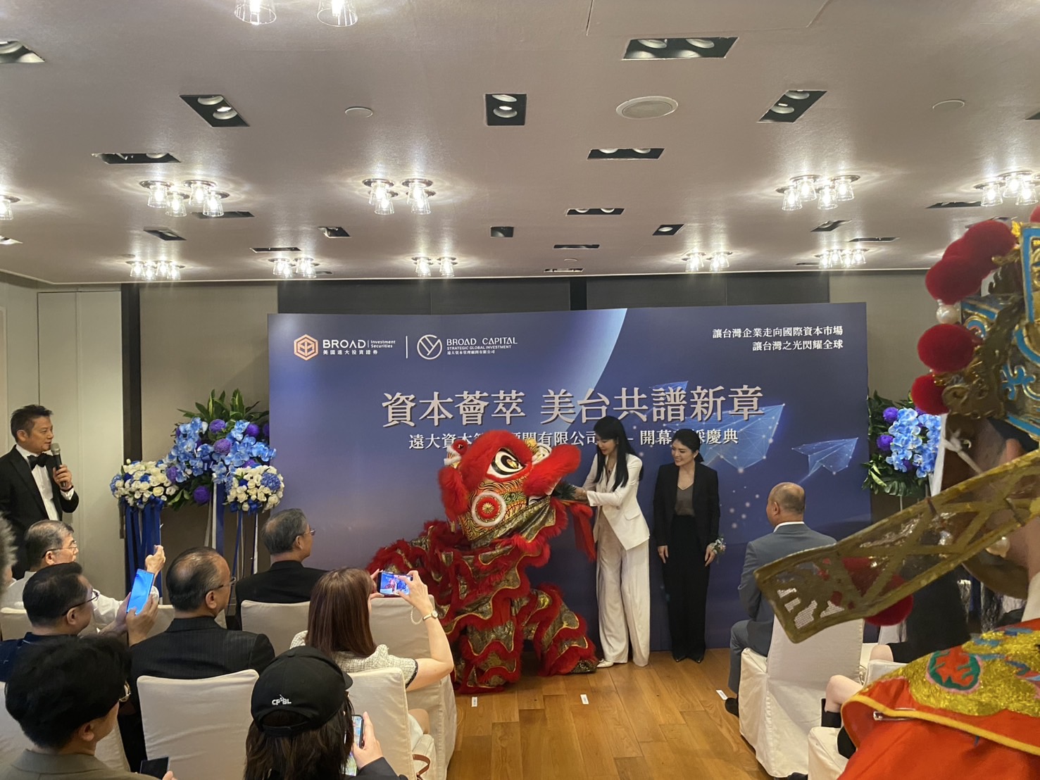 台灣遠大資本管理顧問公司董事長張淑芬從祥獅口中接手象徵好運旺旺來的紅綵鳳梨。(記者包克明 攝)