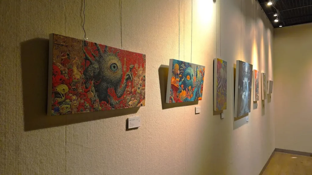 王瑋名的《藝次元》系列作品色彩繽紛、充滿奇幻想像，展現出夢幻般的視覺世界。他表示，這正是人與AI共同構思、協作創作的一種新模式。（圖/陳惠玲攝影）